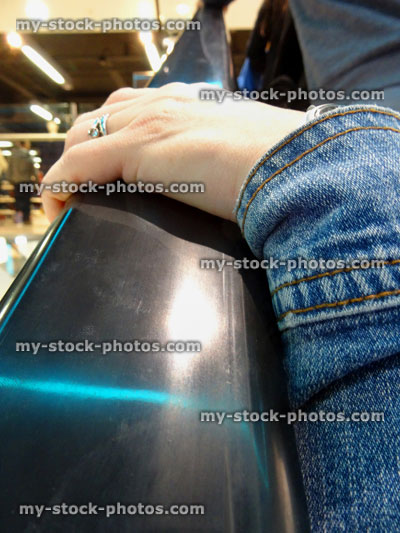 Stock image of girl's hand on escalator handrail / rail, germs, cold, flu virus, shopping mall