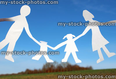 Stock image of family paper chain of people / dolls, dancing against blue sky