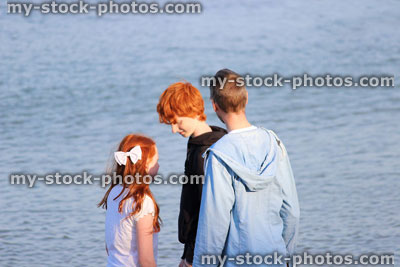 Stock image of family padding in sea / seaside, father, daughter, son