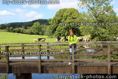 Stock image of girl standing on wooden bridge, river, countryside, looking at view