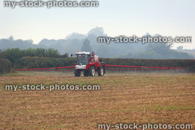 Stock image of farm field being sprayed with chemical insecticide by-farmer