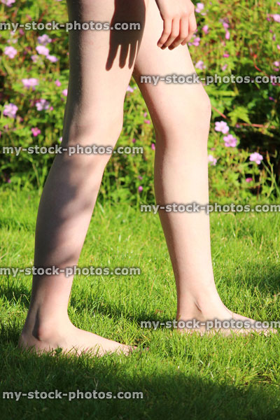 Stock image of girl with long legs walking barefoot on grass