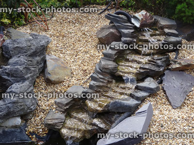 Stock image of realistic plastic, fibreglass waterfall with pond pump / stones