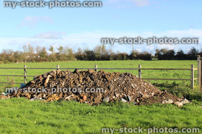 Stock image of field with pile of rubble soil mound / rubbish dump heap / fly tipping