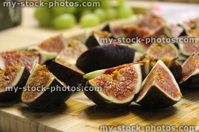Stock image of sliced fresh figs on wooden breadboard, party food