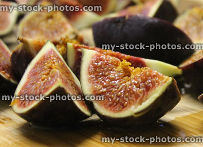 Stock image of sliced fresh figs on wooden breadboard, party food