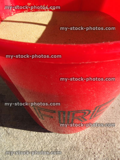 Stock image of red fire bucket filled with sand, petrol / gas fuel filling station