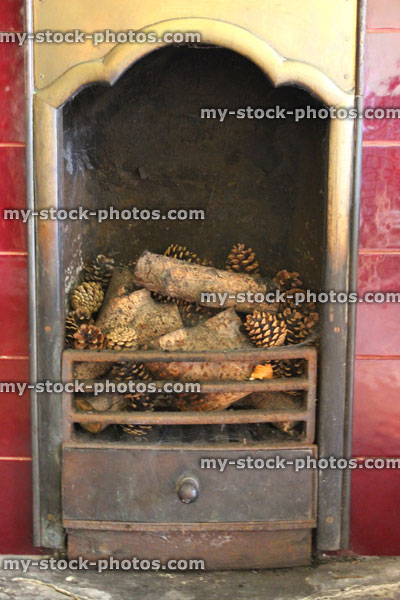 Stock image of Victorian iron fireplace with red tiles, brass, logs