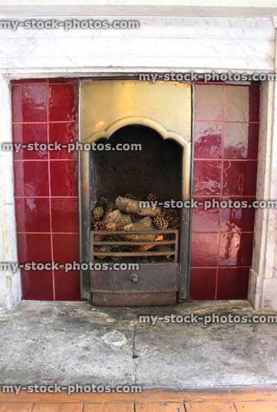 Stock image of iron Victorian fireplace with red tiles, brass, marble
