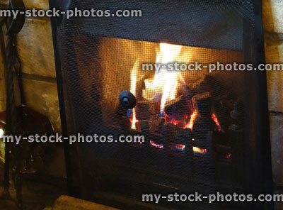 Stock image of black metal wood burner fireplace, roaring fire / flames