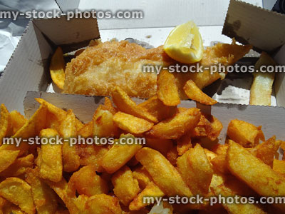 Stock image of battered chips with fish in takeaway cardboard box