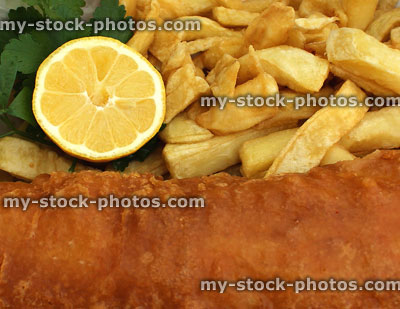Stock image of cod and chips, battered fish, lemon slice, parsley garnish