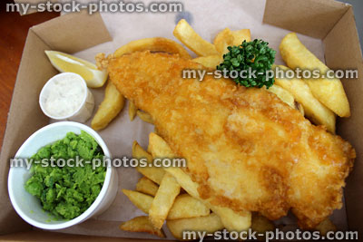 Stock image of fish and chips (cod) in box with peas, tartar sauce