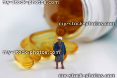 Stock image of mini figure stood by white, plastic pill bottle of vitamins