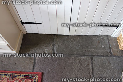 Stock image of white painted wooden tongue and grove doors, with flagstone flooring