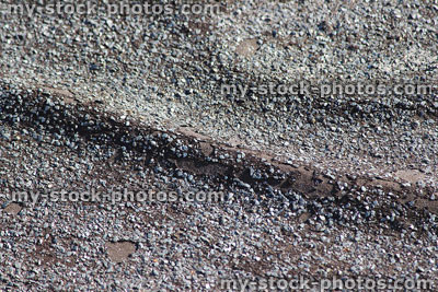Stock image of creased felt flat roof with tar and gravel