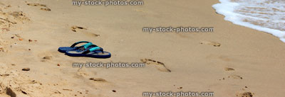 Stock image of flip flops / thongs on sand / seaside, beach sandals banner