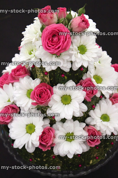 Stock image of floral arrangement, pink roses / white daisy flowers, tiered cake display