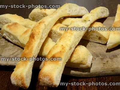 Stock image of criss cross focaccia bread strips / sliced, served on wooden board