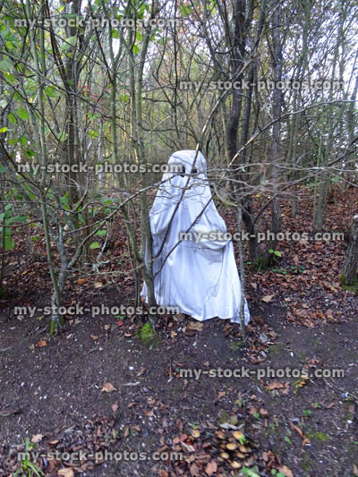 Stock image of woodland ghost made from white bed sheet, Halloween haunted forest