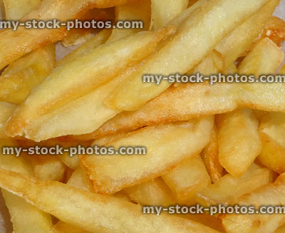 Stock image of golden, greasy French fries / deep fried chips from burger bar