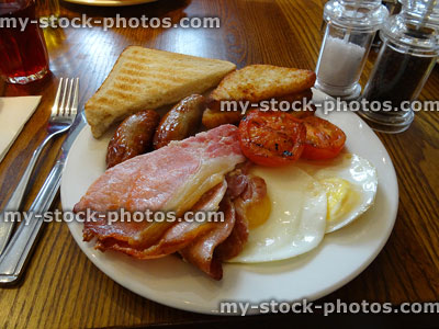 Stock image of traditional English fry up / fried breakfast, sausages, bacon, fried bread egg