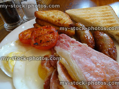 Stock image of greasy English fry up / traditional fried breakfast, sausages / bacon