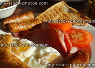 Stock image of greasy fried breakfast with sausages, eggs, bacon, tomatoes