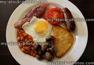 Stock image of fried breakfast, with bacon, sausage, egg, mushrooms, tomato