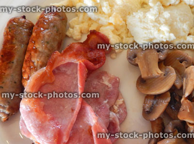Stock image of fried breakfast, sausages, bacon, fried mushrooms, scrambled eggs