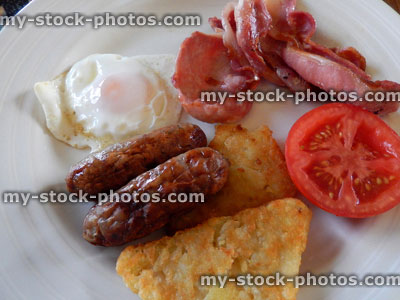 Stock image of fried breakfast with sausages, bacon, hash brown, tomato