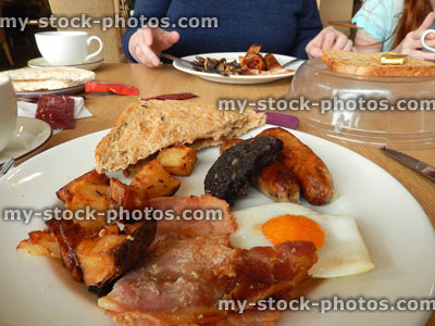 Stock image of family eating full English breakfast / fry up in 'greasy spoon' cafe