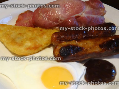 Stock image of full English fried breakfast, sausages, bacon, fried egg, hash browns