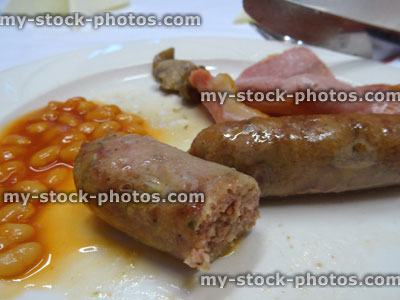Stock image of half eaten fried breakfast, eating sausages, smoky bacon, baked beans, full English
