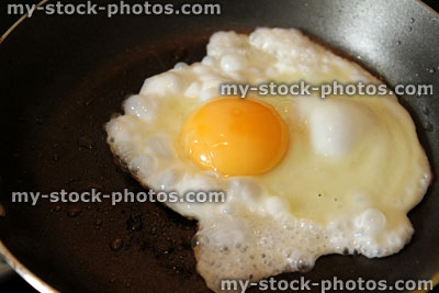 Stock image of fried egg being cooked in non stick frying pan