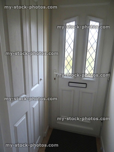 Stock image of modern white UPVC front door with panels, lattice windows / porch cupboard