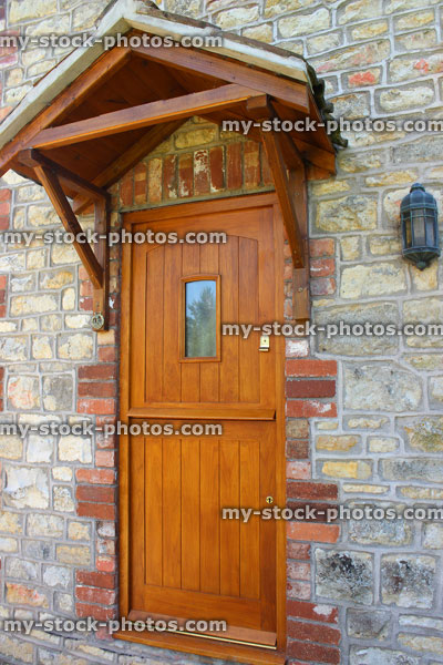 Stock image of wooden front door to cottage, historic stone wall