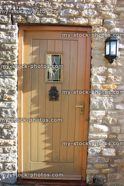 Stock image of wooden front door / back door knocker, cobblestone wall