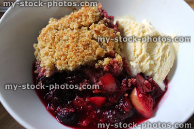 Stock image of apple and summer fruit crumble with ice cream