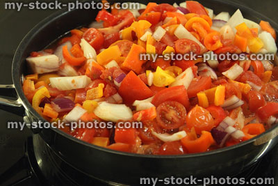 Stock image of frying pan of vegetables, cooking tomatoes, yellow peppers, onions