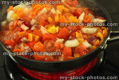Stock image of ceramic hob cooker with frying pan cooking vegetables