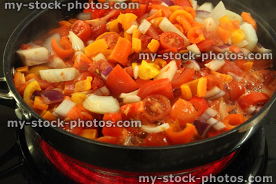 Stock image of halogen ceramic cooker ring with vegetables in frying pan