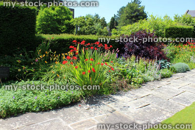 Stock image of summer flower bed / herbaceous border, daylilies, crocosmia, geraniums, stachys, penstemon