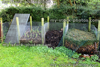 Stock image of wire recycling compost heaps in shady garden corner