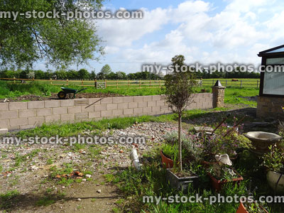 Stock image of new concrete block garden wall, backyard landscaping project