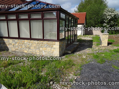 Stock image of new square conservatory with glass roof, vertical blinds