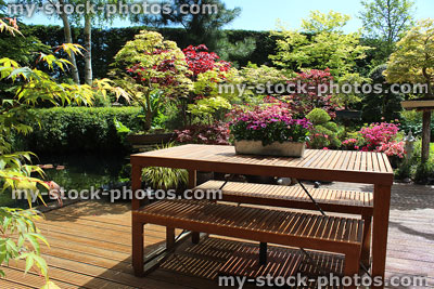 Stock image of wooden garden decking, oriental furniture, table and benches