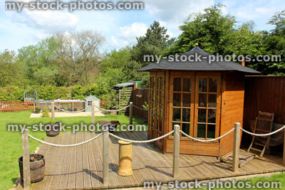 Stock image of wooden gazebo / summer house on decking timber in ornamental garden