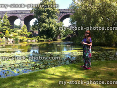 Stock image of young girl in gardens next to lily pond