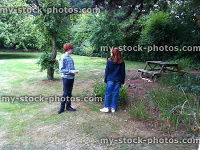 Stock image of children in playing in back garden, dry lawn